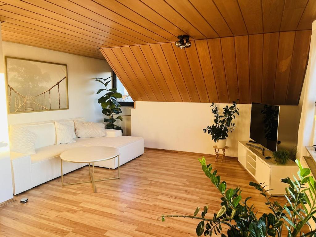 a living room with a white couch and a wooden ceiling at Ferienwohnung in Wörnitz in Unterwörnitz