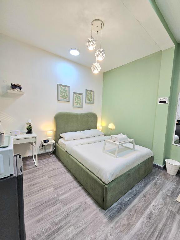 a bedroom with a large bed and a desk at Green Zen Studio Metro 15 mins walk away in Dubai