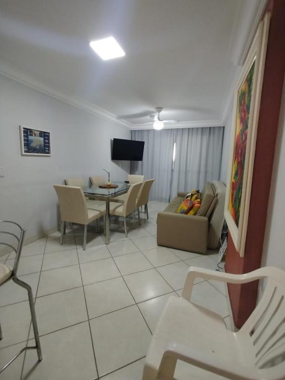 a living room with a couch and a table and chairs at Diamante guarapari in Guarapari