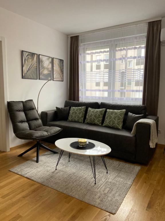 a living room with a black couch and a table at Angel Apartment in Subotica