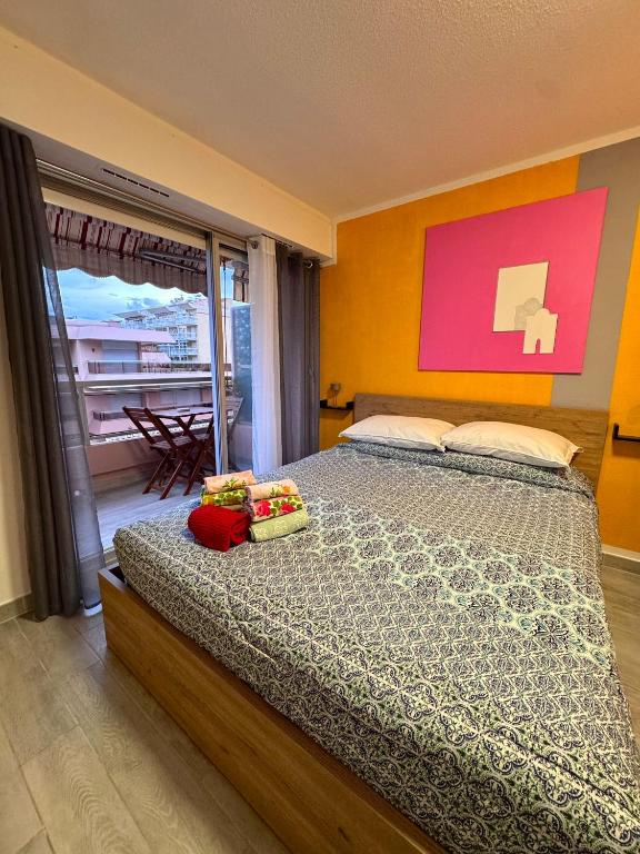 a bedroom with a bed and a large window at Riviera Begonia Appartement - Parking Privé in Roquebrune-Cap-Martin