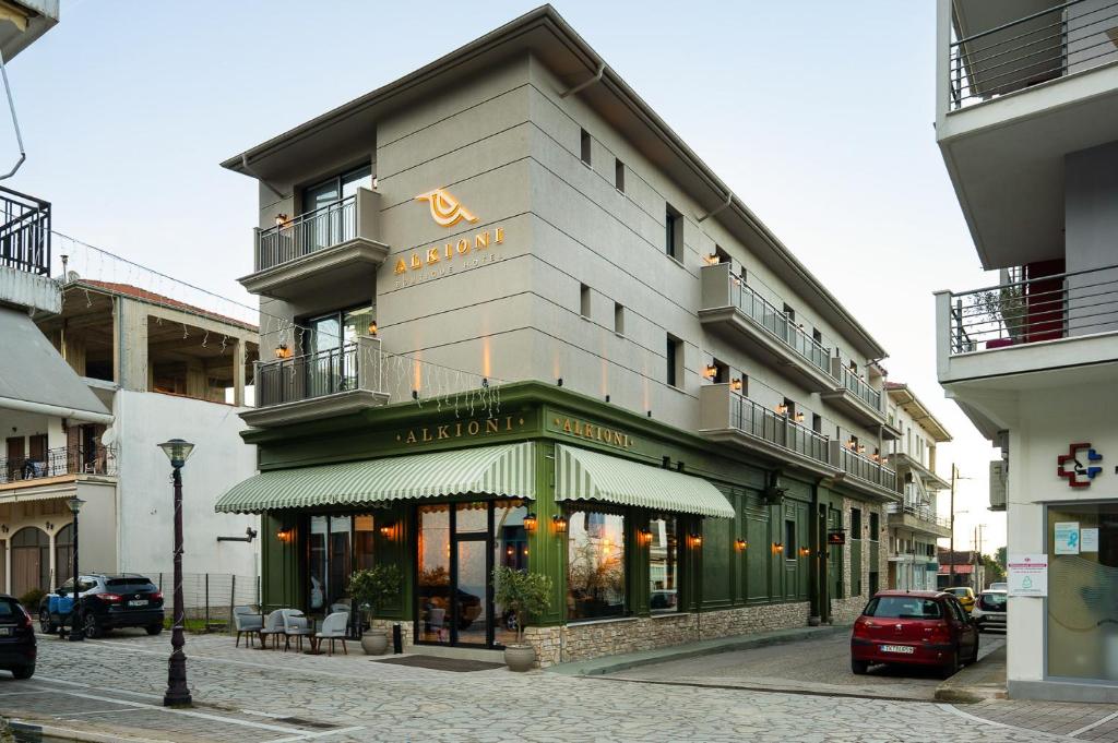 a building with a sign on it on a street at Alkioni Boutique Hotel in Pýli