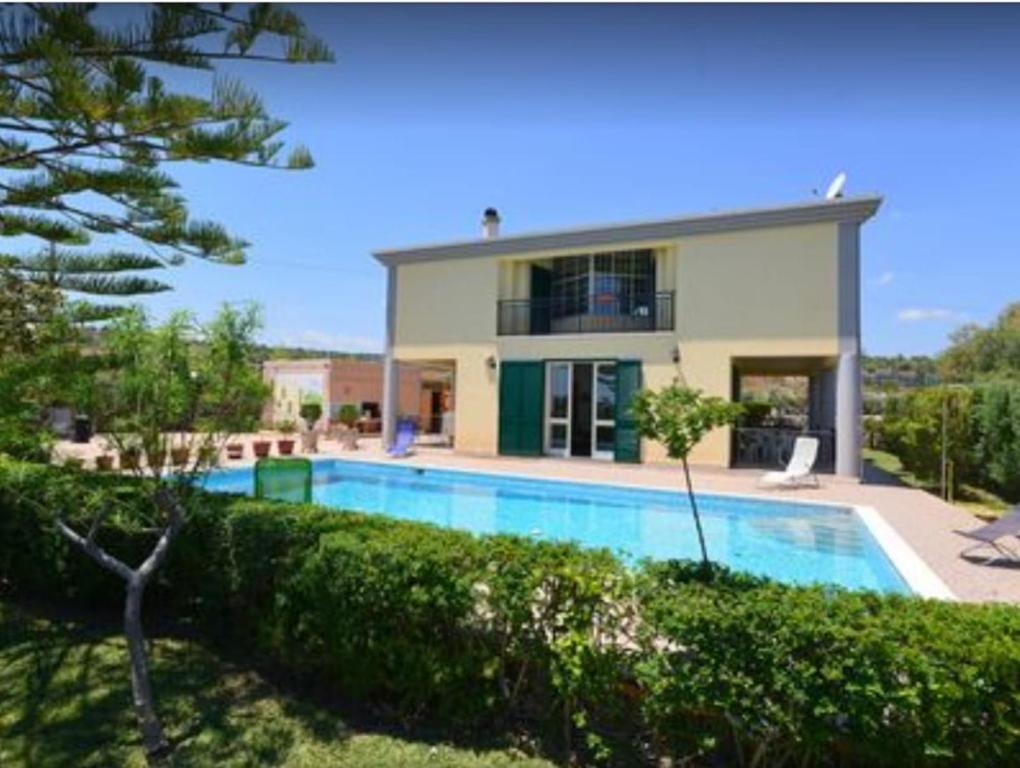 a house with a swimming pool in front of a house at Villa Sara in Floridia