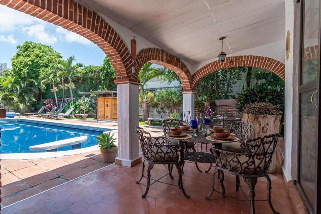 a patio with a table and chairs next to a pool at Quinta Rustica "La Aguacana" in Cuautla Morelos