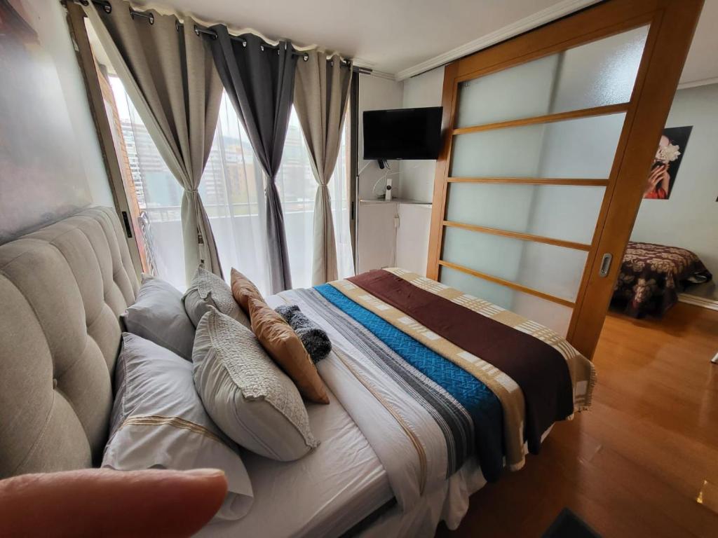 a bed with pillows on it in a room with a window at Living Suite in El Cerrillo