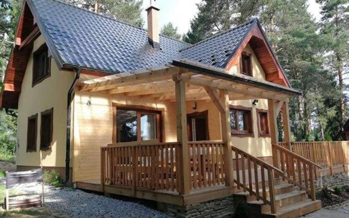 a small wooden cabin with a large deck at Chaty Slovensky Raj Veronika in Smižany