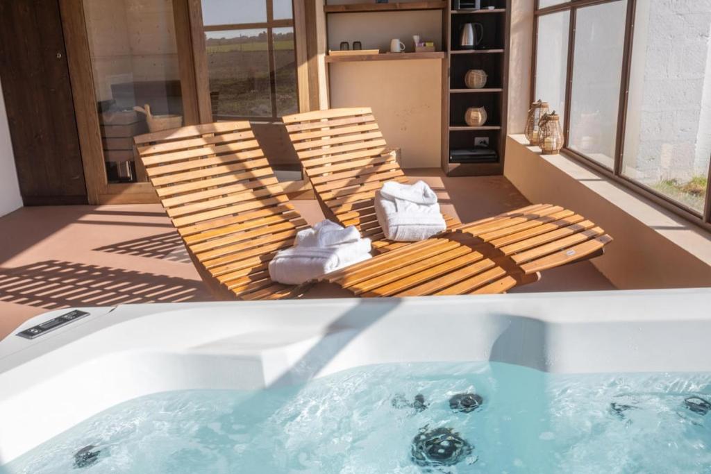 a hot tub with a chaise lounge and a chair next to a hot tub at Suite & Spa Carignano Grande in Nardò