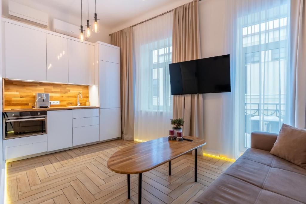 a living room with a table and a couch at Picturesque Old Town Apartment with Charming Balcony in Kaunas