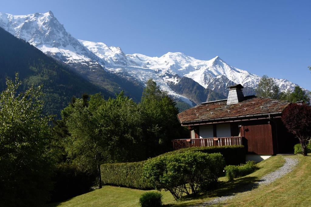 une petite maison avec une montagne en arrière-plan dans l'établissement Chamonix Balcons du Mont Blanc, à Chamonix-Mont-Blanc