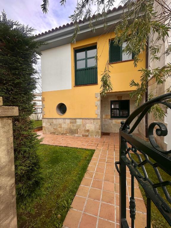a yellow and white house with a window at Cala Tatina in Celorio