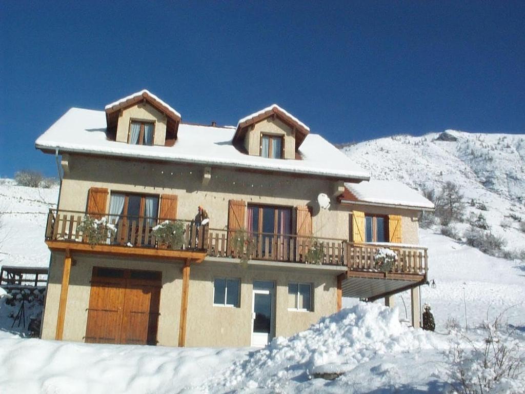 a snow covered house with a balcony in the snow at Les Hauts Des Auches in Ancelle