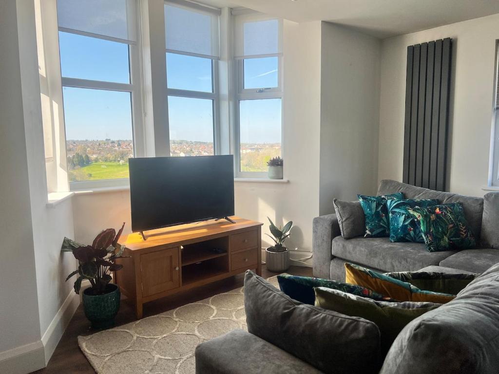 a living room with a flat screen tv on a wooden stand at Upper Valley View in Keynsham