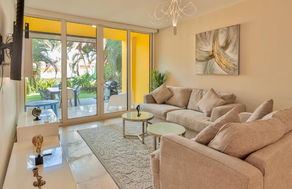 a living room with a couch and a table at Modern Ground Level, 4 BR condo in Palm-Eagle Beach