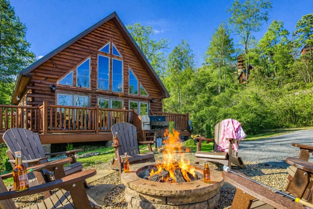 a fire pit in front of a log cabin at Ridge Hollow Retreat - Hot Tub, Fire Pit, Dogs in Gatlinburg