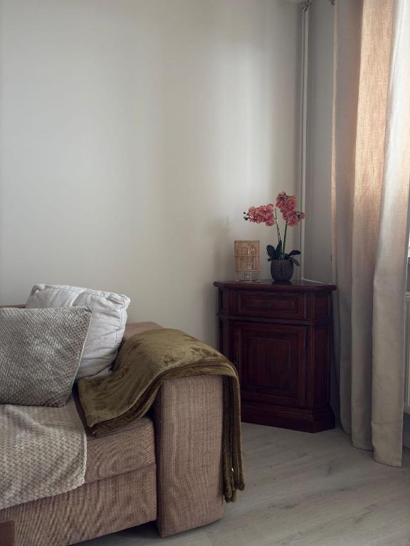 a room with a couch and a vase with flowers on a table at Rodzinna Przystań in Białystok