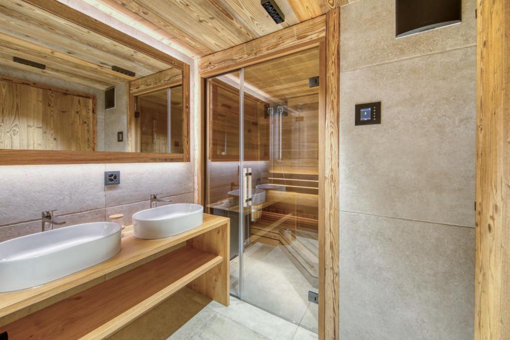 a bathroom with two sinks and a mirror at Central High-End Duplexes, Sauna and Stove in Champéry