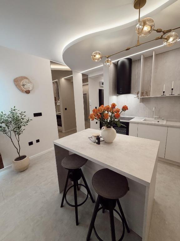 a kitchen with a table with flowers on it at Mediteran Line Apartman 1 in Sombor