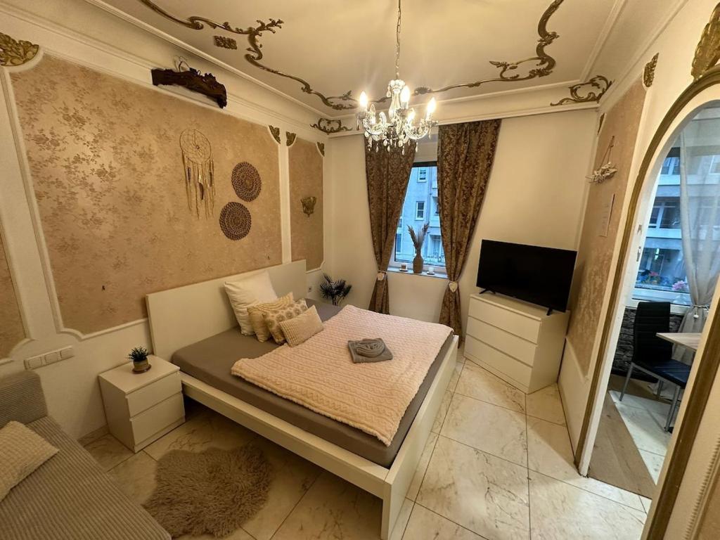 a small bedroom with a bed and a tv at City Honor Extravagance in Linz