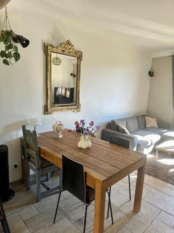 a dining room table with a mirror and a couch at Cocon en Provence à Ménerbes in Ménerbes