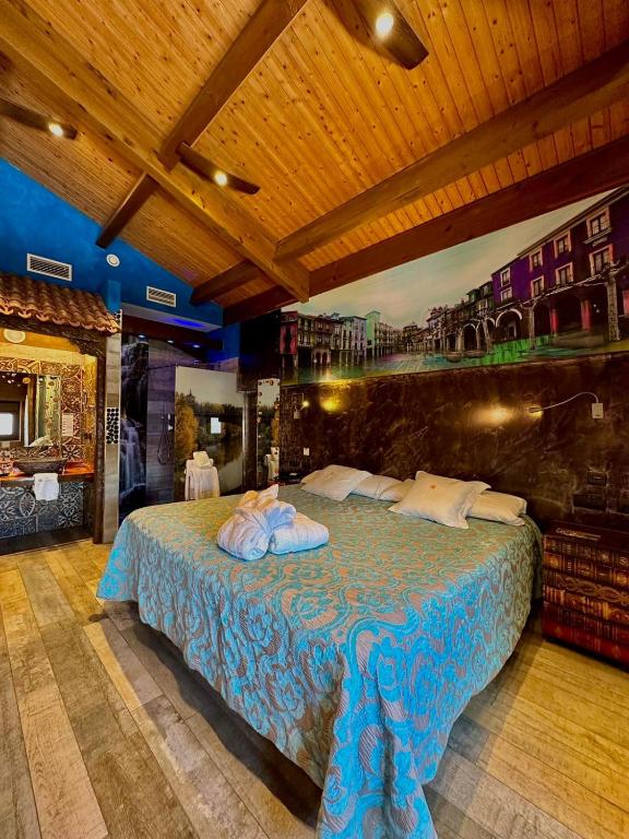 a bedroom with a large bed with a blue blanket at Hotel SPA El Lagar de Isilla in La Vid y Barrios