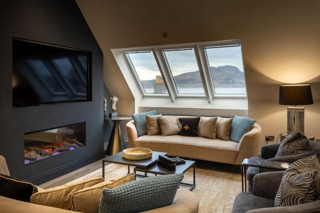 a living room with a couch and a fireplace at Arran Shores Luxury Shorefront Penthouse Suite 11 in Lamlash