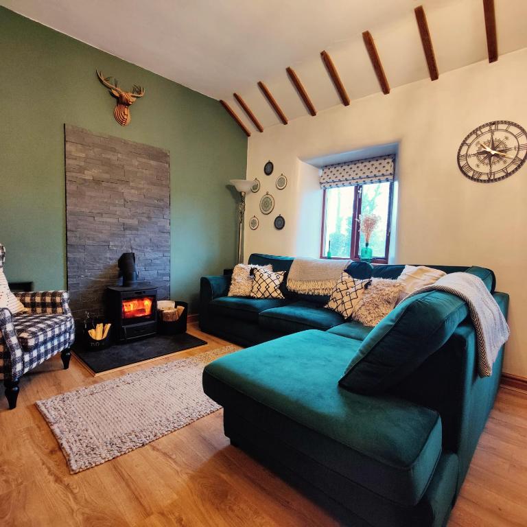 a living room with a couch and a fireplace at Hebron Rural converted chapel in Nantglyn