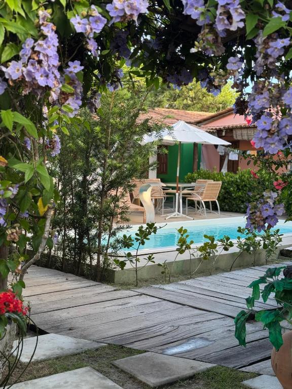 a backyard with a pool and a table and chairs at Casa Recanto- Vila Uryah in Caraíva