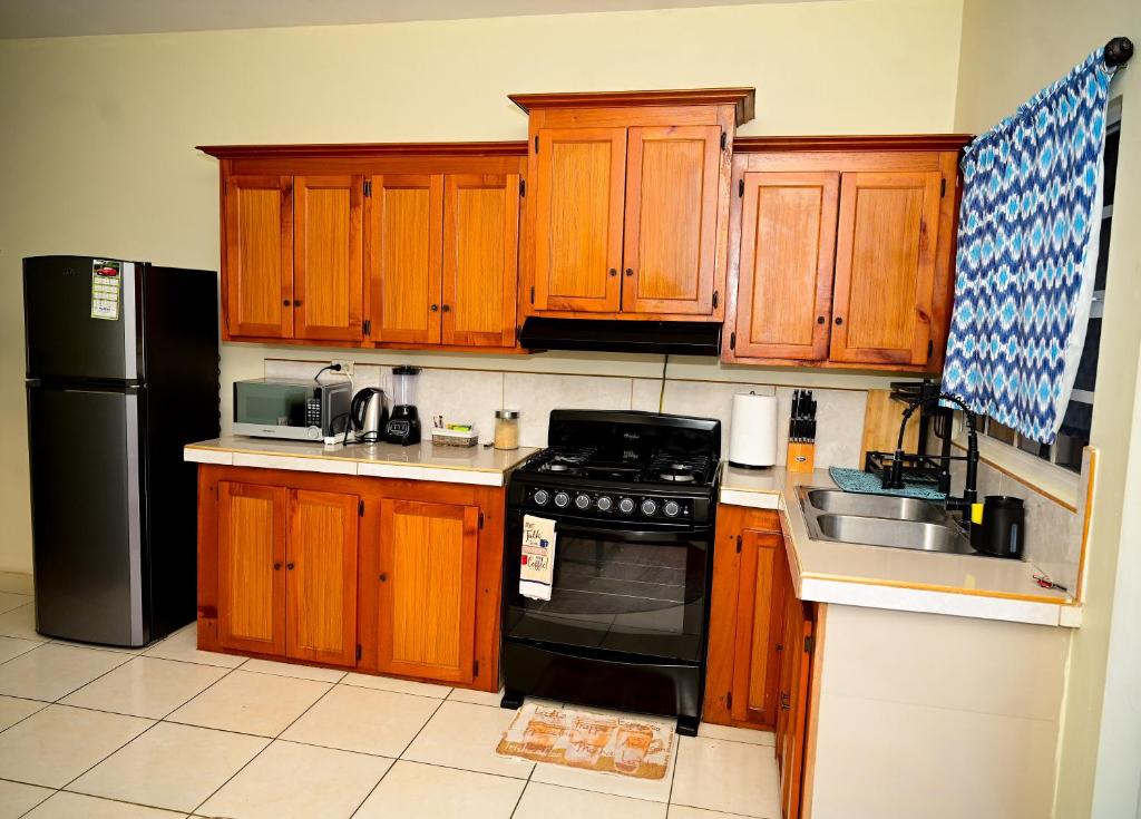 a kitchen with wooden cabinets and a black stove at Cozy one bedroom & Car rental apartment in Lambeau