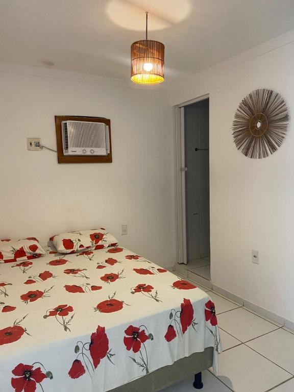 a bedroom with a bed with red flowers on it at Luar Dos Milagres in São Miguel dos Milagres