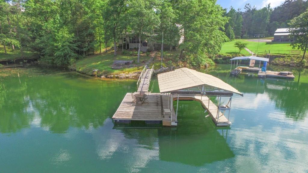a dock in the middle of a lake at Rocking W - Screened In Porch And Lakeside Fire Pit! in Double Springs