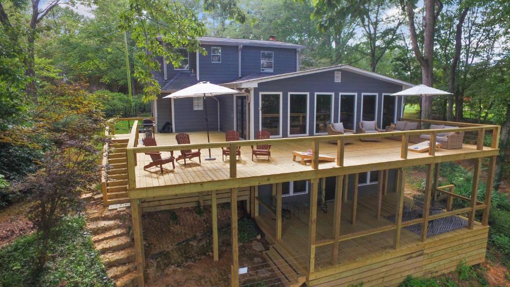 a house with a deck with chairs and tables at Carols Cottage - Double Decker Dock! Popular Location! in Cullman