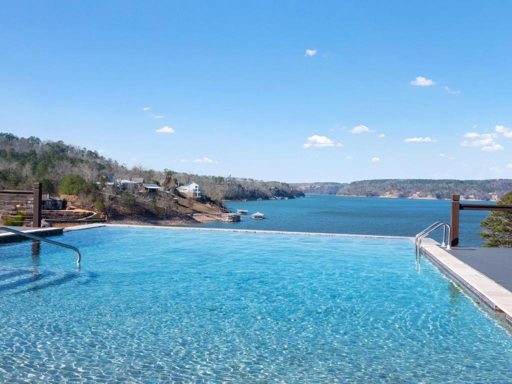 a large swimming pool with a view of a lake at Mallard Pointe 100 - Luxury Condo- Conveniently Located! in Cullman