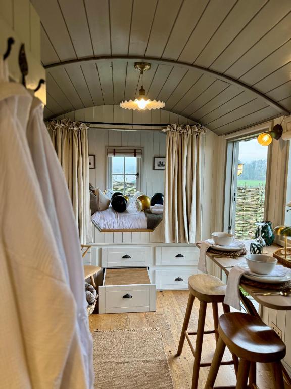 a bedroom with a bed and a table and chairs at The Hut at Claston in Stoke Edith