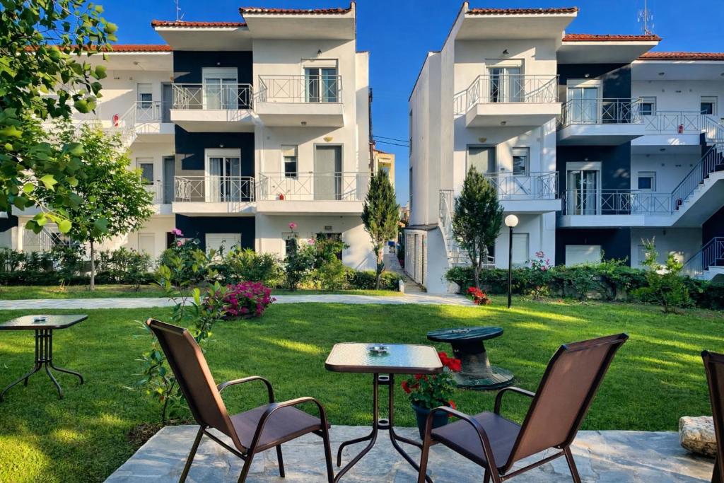 a patio with chairs and tables in front of a building at DOMES APARTMENTS in Kallithea Halkidikis