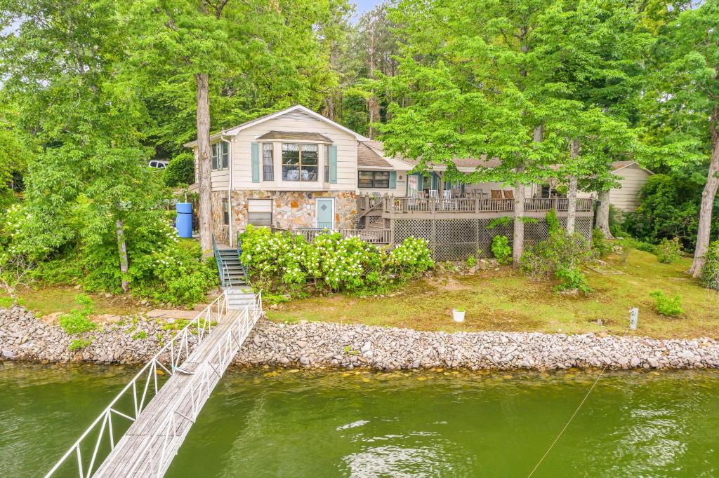 a house with a bridge over a river at Nanas Lakehouse - Private Dock With Jet-Ski Port! in Jasper