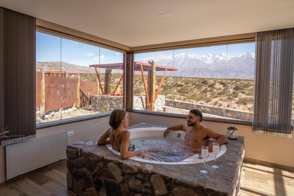 a man and a woman sitting in a bath tub at Potre casas de montaña in Potrerillos