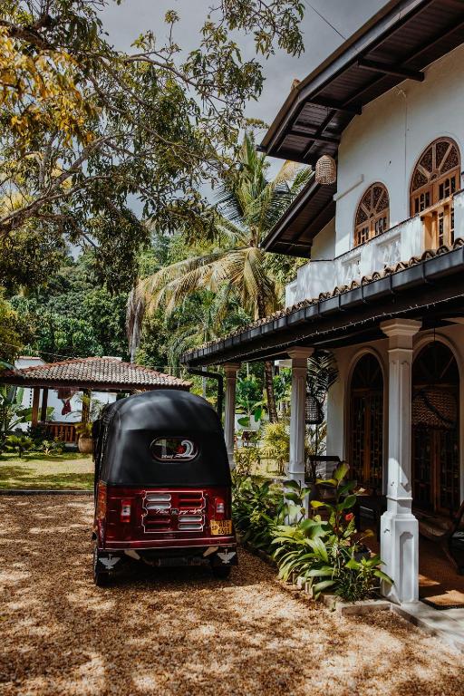 a red and black van parked in front of a house at Tara Luxury House in Habaraduwa Central