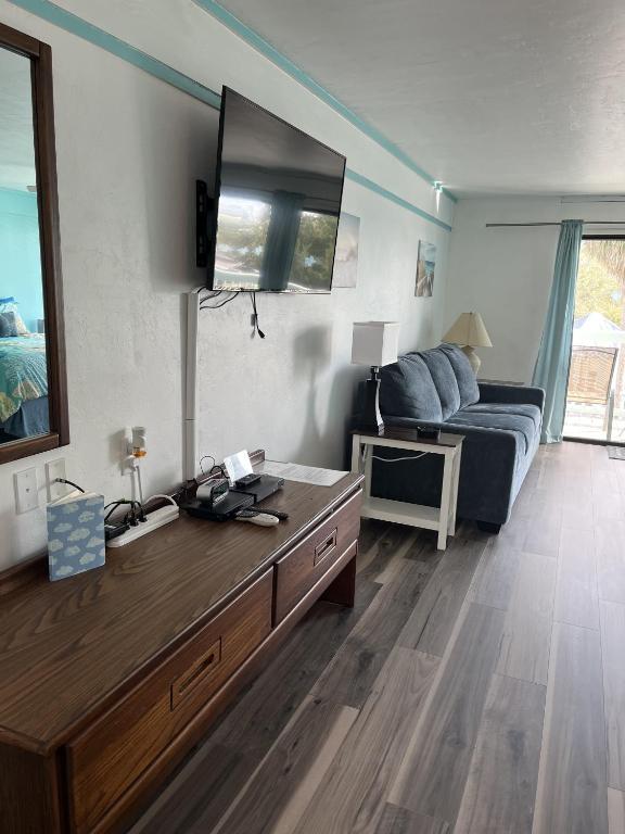 a bedroom with a bed and a tv on the wall at Renovated Ocean-View Condo with Private Balcony in Cedar Key