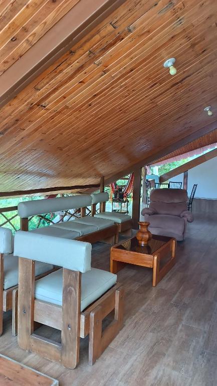 a room with chairs and a couch and a wooden ceiling at Mindo Suites - Toucans in Quito