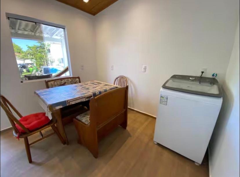 a small room with a table and a refrigerator at Casa do Aconchego - Quitinete I in Governador Celso Ramos