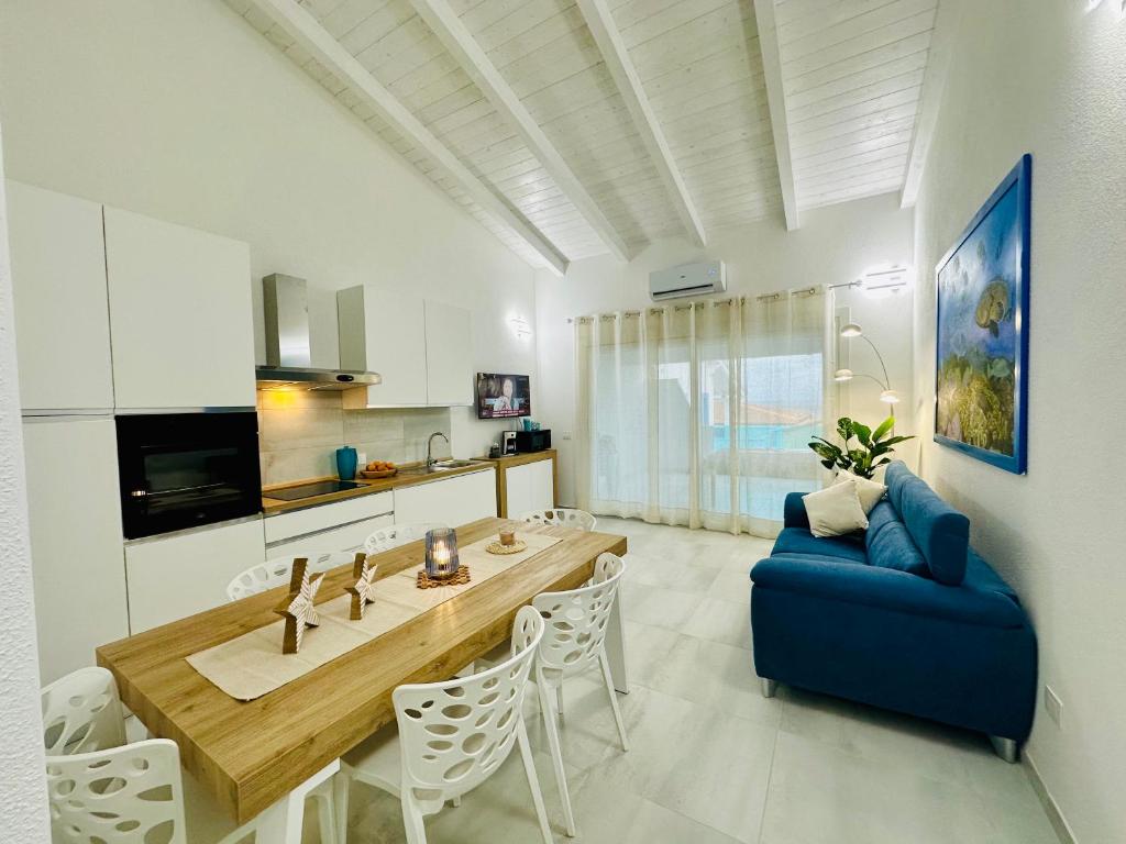 a living room with a table and a blue couch at AZZURRO meraviglioso attico a pochi passi dal mare in Valledoria