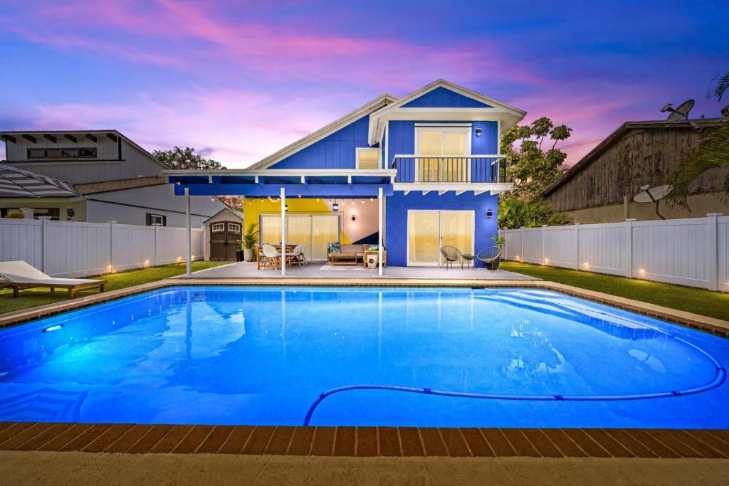 a blue swimming pool in front of a house at Sunset Haven with Saltwater Pool & mins to beach in Delray Beach