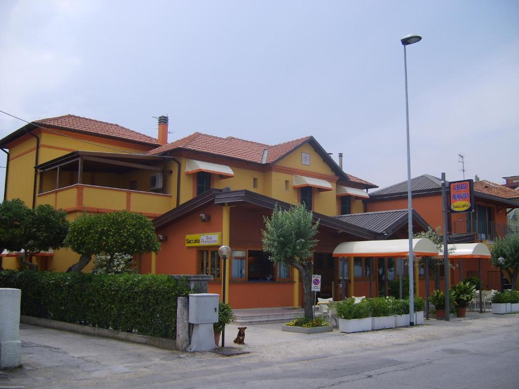 a yellow and orange building on a street at Albergo Primavera in Senigallia