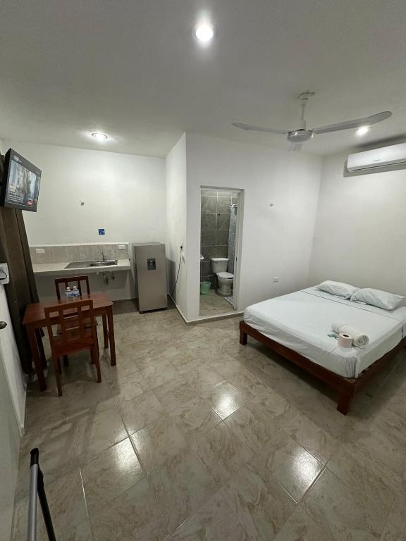a bedroom with a bed and a table and a bathroom at Hotel AF 14 in Tizimín