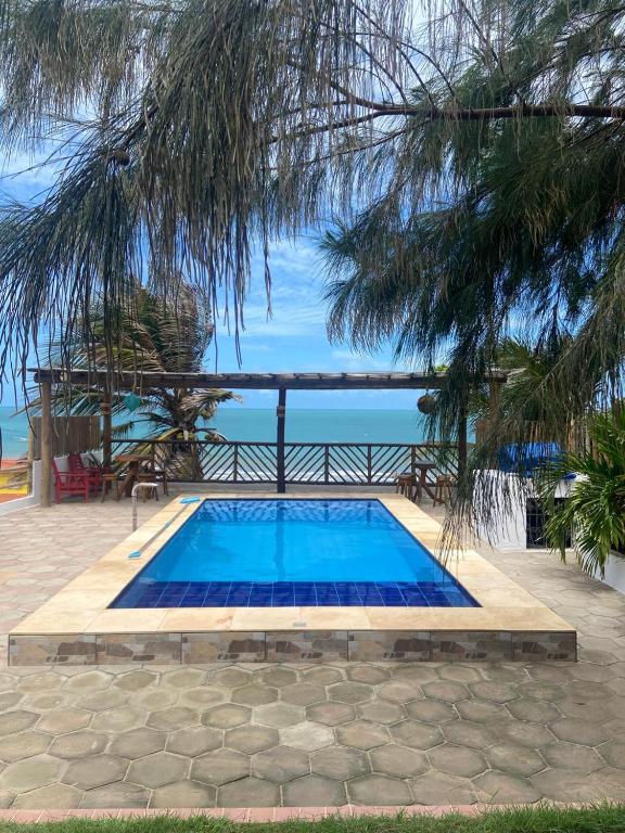 a blue swimming pool with the ocean in the background at Casa Mar Alto in Icapuí