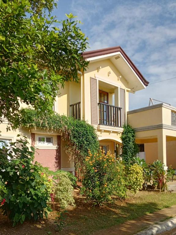 a yellow house with a balcony and some bushes at Noah Bed&Breakfast 3 Private Room NEWHOME Quiet Place to Stay 14 Minutes to PPS Airport in Puerto Princesa City