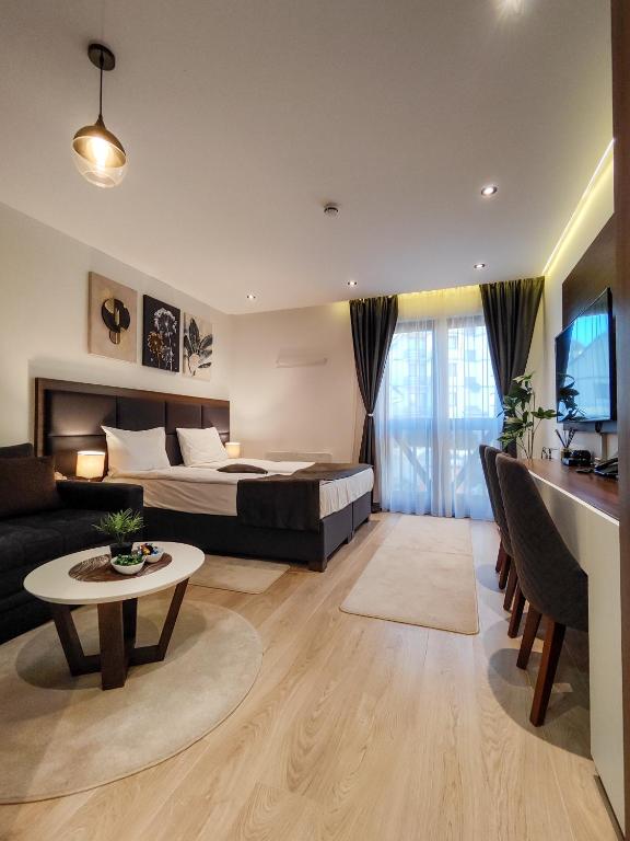 a bedroom with a bed and a living room at Zoned MASLAČAK lux - SPA & Wellness Kopaonik in Kopaonik
