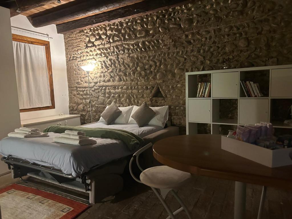 a bedroom with two beds and a table in it at Teatro Vecchio 11 in Bassano del Grappa