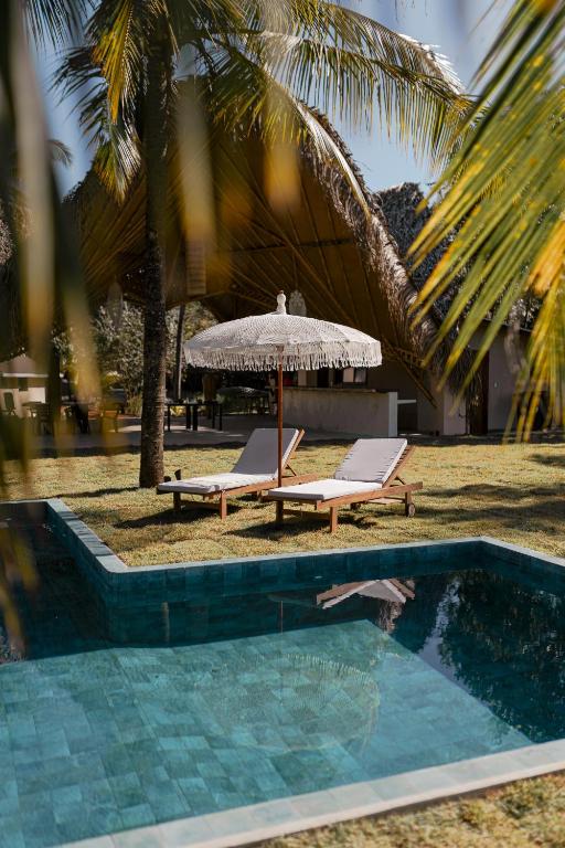 a swimming pool with two lounge chairs and an umbrella at Manta Project in Morrillo