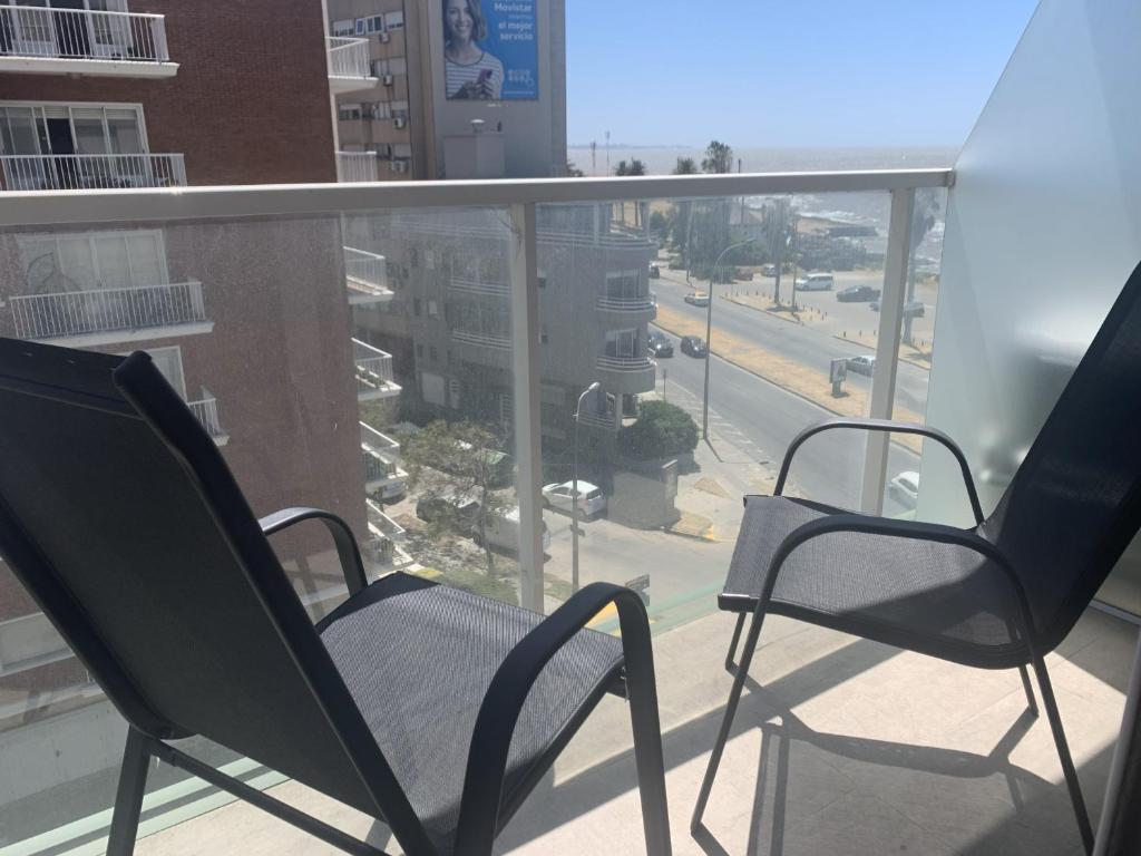 two chairs on a balcony with a view of a street at Punta Carretas Vista al Mar in Montevideo
